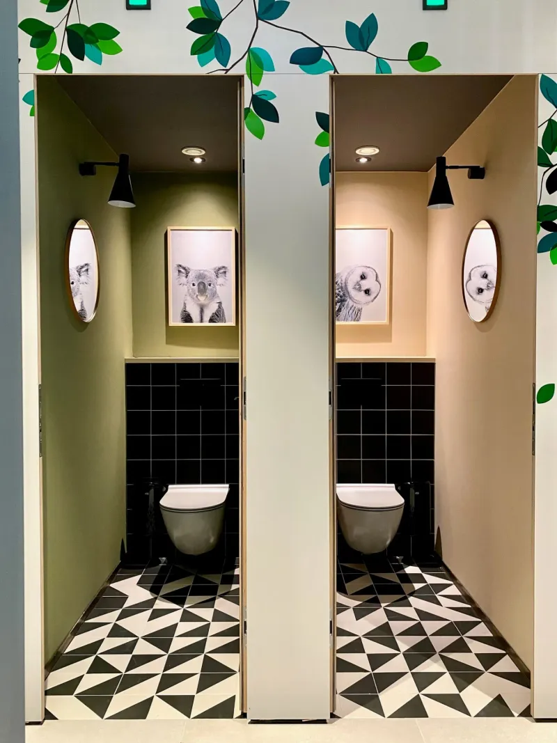 WC-Kabinen mit Tier-Kunstdrucken und Blattmotiv-Wandbild