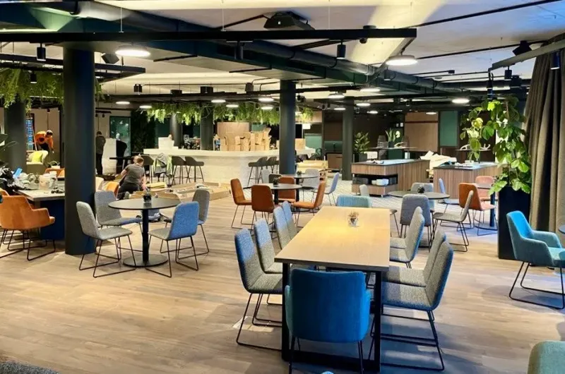 Großer Dining-Bereich mit gemischten Stühlen und Pflanzensäulen